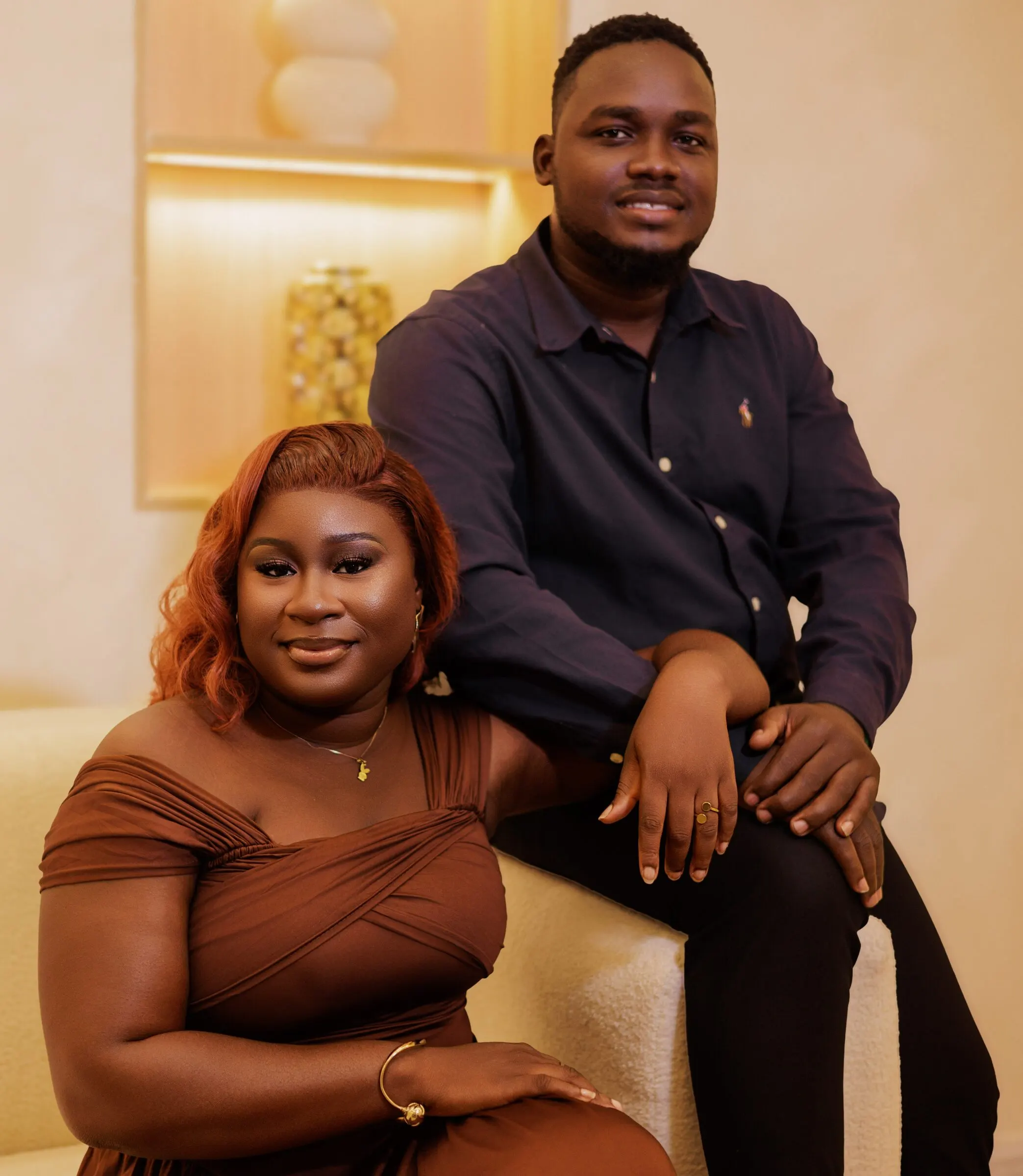 Marina in a brown dress seated beside Mark